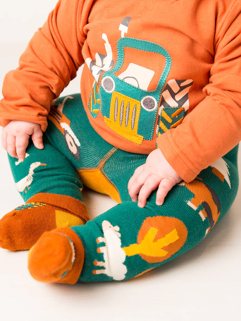 Blade & Rose Rustic Farmyard Top. Child wearing an orange shirt with a truck design and green pants with animal prints on a white background