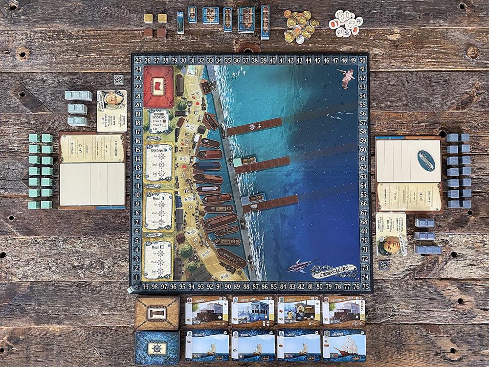 Board game setup on a wooden surface with various game pieces and cards.