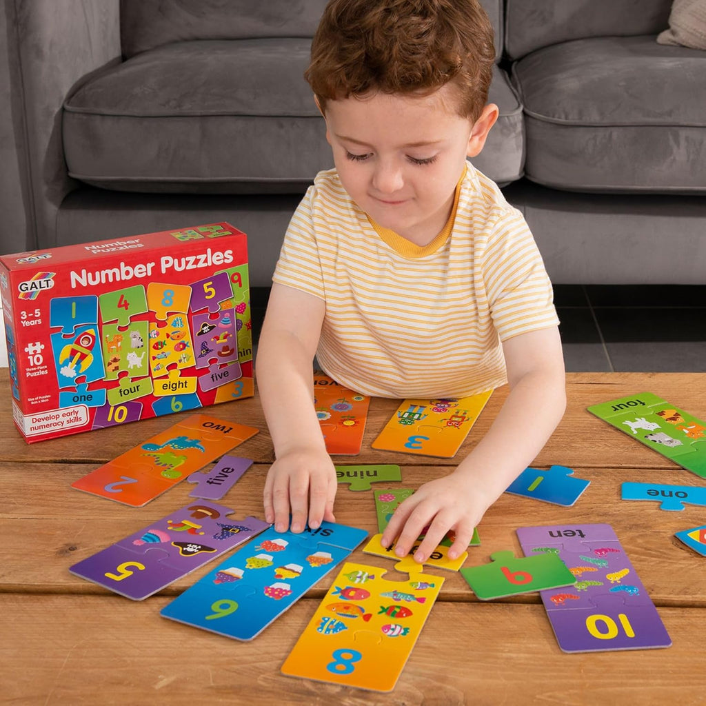 Galt Number Puzzles. Child playing with number puzzles on a wooden table, with a Galt Number Puzzles box in the background.