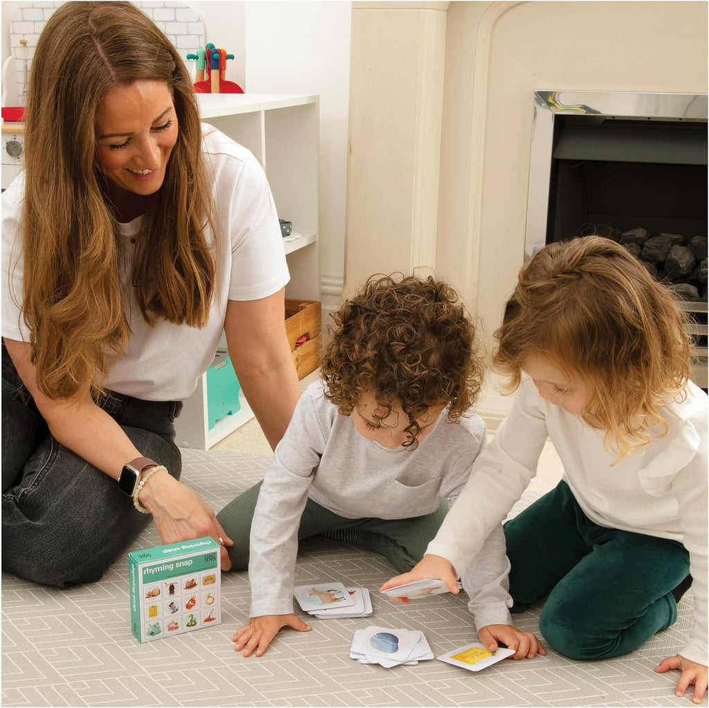 Galt Rhyming Snap. Woman and two children playing with educational cards on the floor in a home setting.