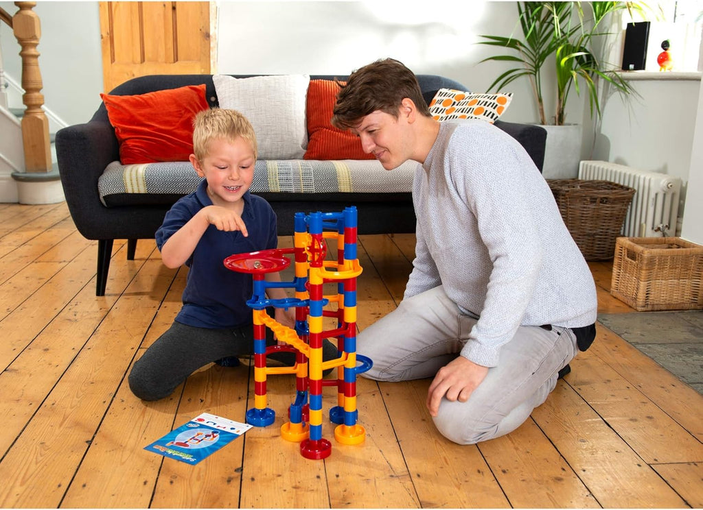 Galt Super Marble Run. Two children playing with a colorful marble run set on a wooden floor.