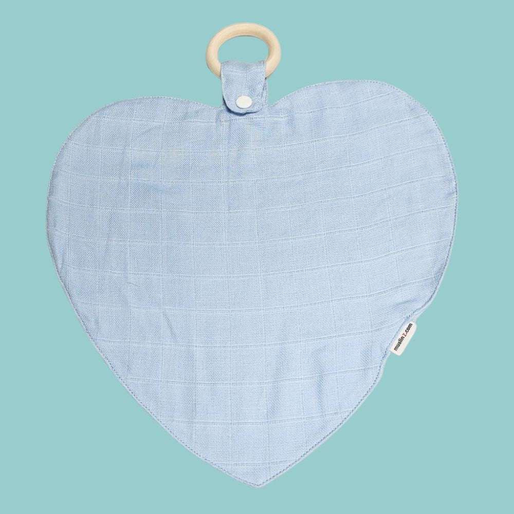 Muslinz Mini Muzi - Pale Blue. Heart-shaped baby teether with a wooden ring on a teal background