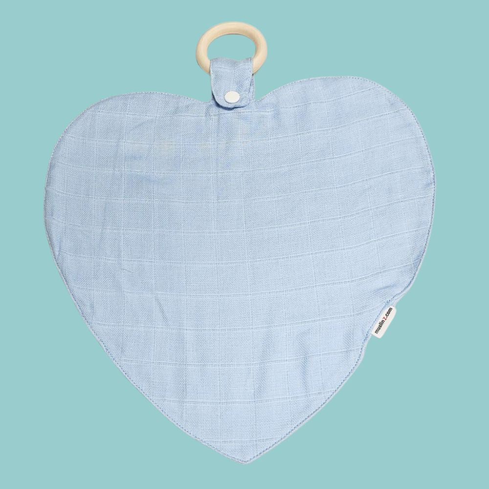 Muslinz Mini Muzi - Pale Blue. Heart-shaped baby teether with a wooden ring on a teal background