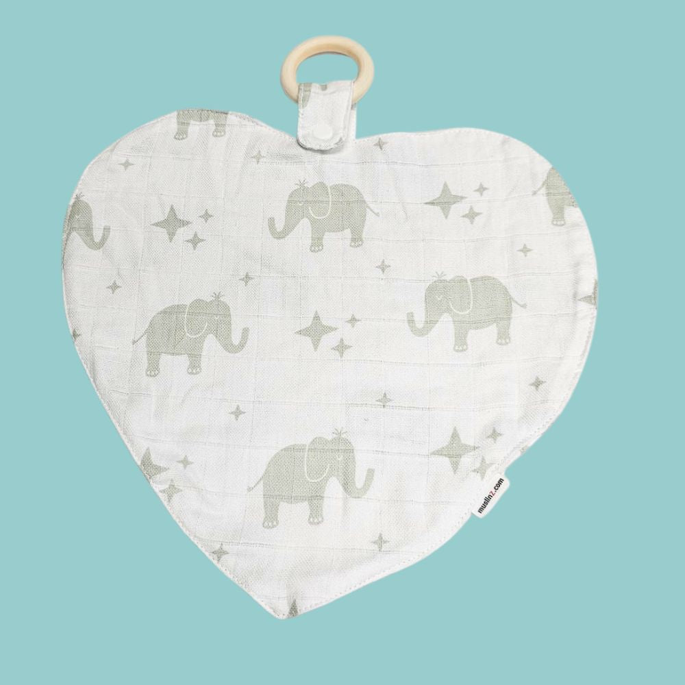 Muslinz Mini Muzi - Elephant. Heart-shaped baby teether with elephant pattern on a light blue background