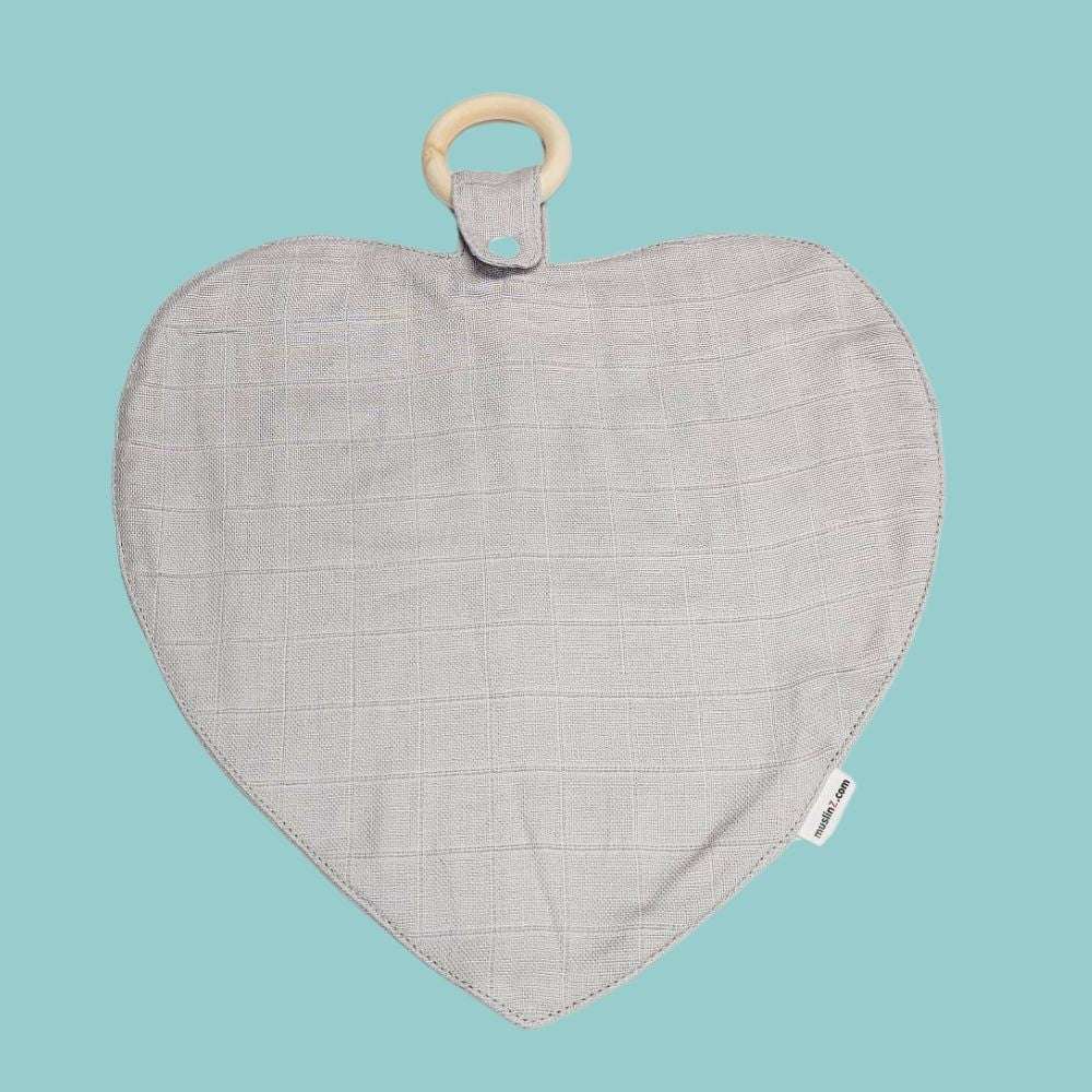 Muslinz Mini Muzi - Sensory. Heart-shaped fabric baby muslin with wooden ring on a light blue background