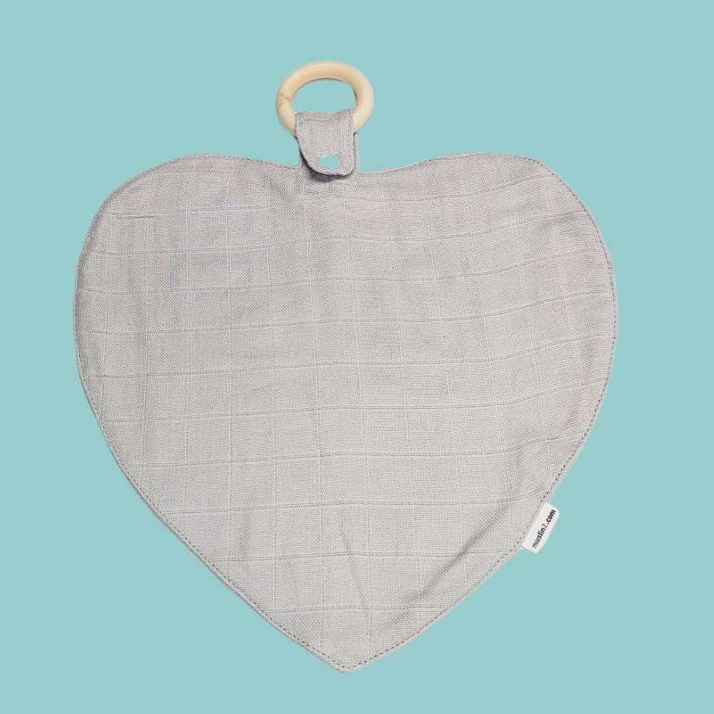 Muslinz Mini Muzi - Sensory. Heart-shaped fabric baby muslin with wooden ring on a light blue background