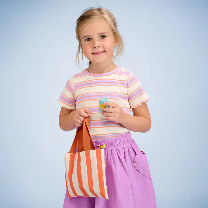 Mentari Bargain Grocery Bag - Young girl holding a striped bag against a light blue background