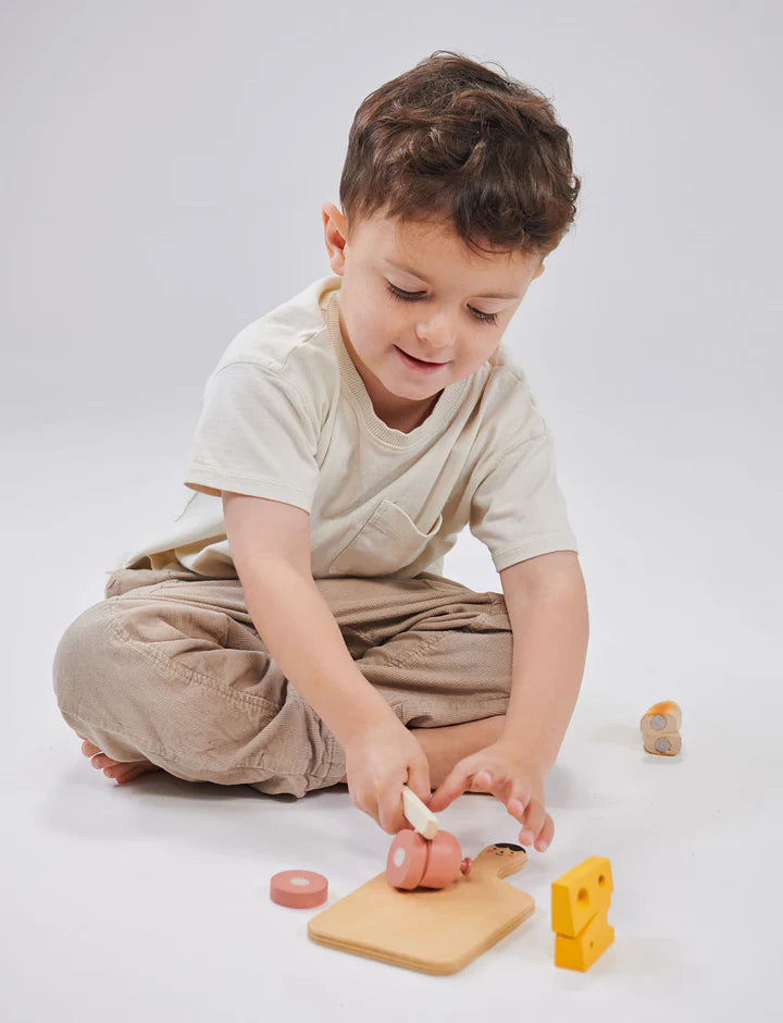 Mentari Smiley Charcuterie Chopping Board. Child playing with wooden toys on a white background