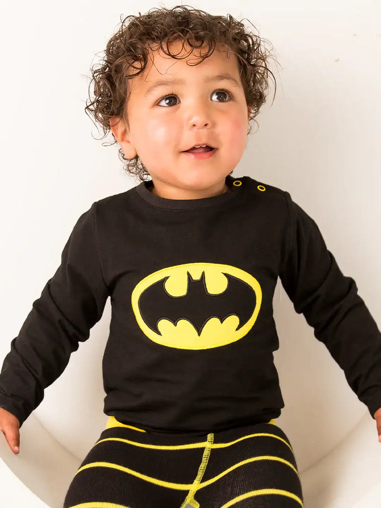 Blade & Rose Batman Top. Child wearing a black long-sleeve shirt with a yellow Batman logo and striped pants.