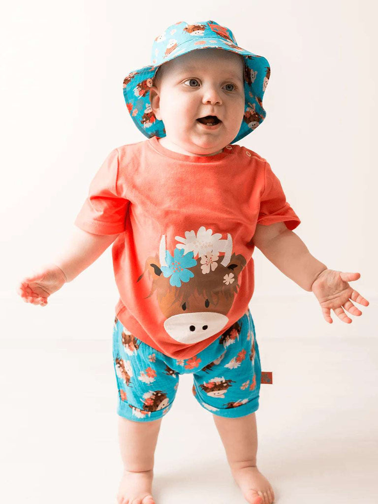 This gorgeous bright orange short-sleeved t-shirt features a cheeky Highland Coo Bonnie face with pretty floral detail.