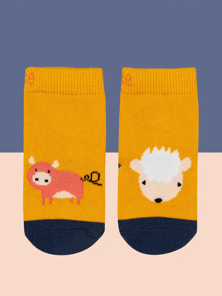 Blade & Rose Meadow Farmyard Socks. Two mustard yellow socks with animal illustrations on a beige and blue background