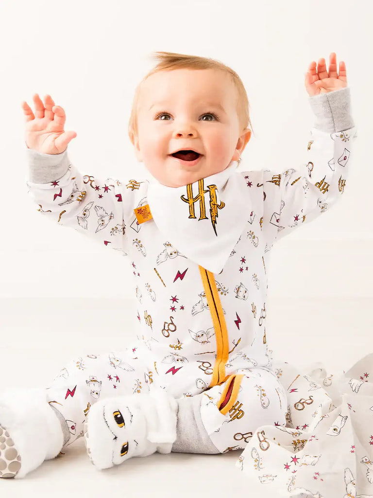 Blade & Rose Harry Potter Hedwig Owl Zip-Up Romper. Baby wearing a patterned onesie with raised arms on a white background