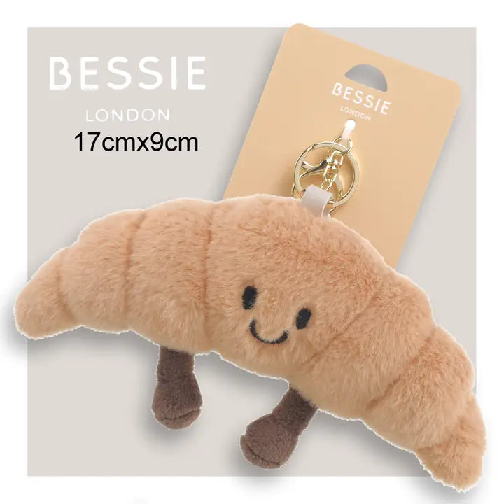 Cute Bessie London Croissant Bag Charm with soft plush fur and embroidered face fun accessory for bags, backpacks, or keys. Shop now