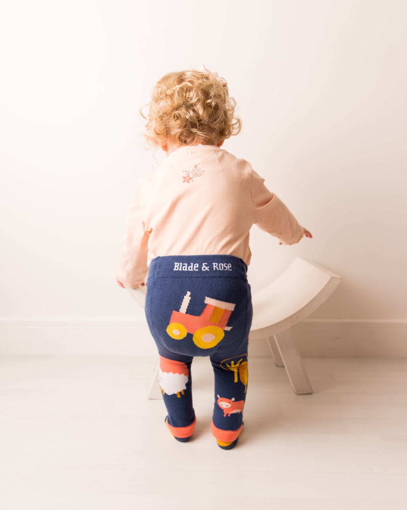 Blade & Rose Meadow Farmyard Leggings. Child wearing navy leggings with a tractor design and 'Blade & Rose' branding, standing on a white floor.