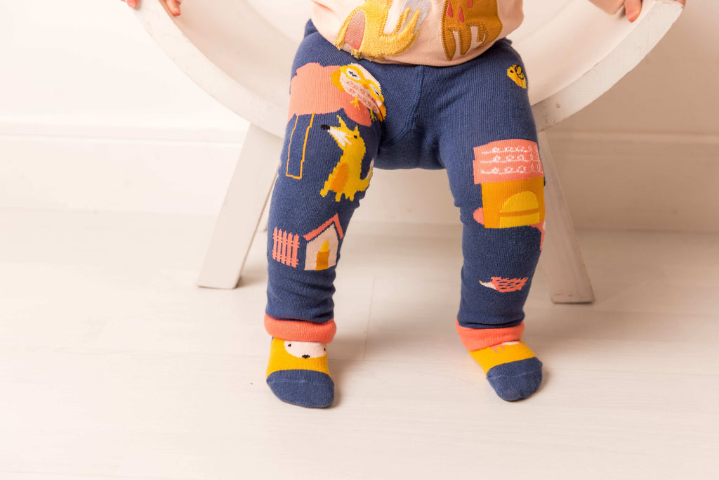 Child wearing colorful leggings with animal prints on a white background. Blade & Rose Meadow Farmyard Leggings