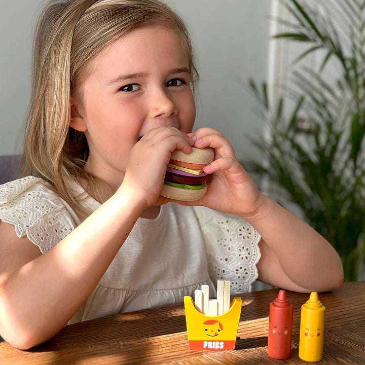 Mentari Mentari Take-out Burger Set. Child playing with a wooden toy hamburger set on a table.