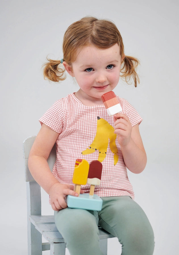 Mentari Sunny Ice Lollies. Child holding a toy with colorful popsicle-like shapes against a plain background