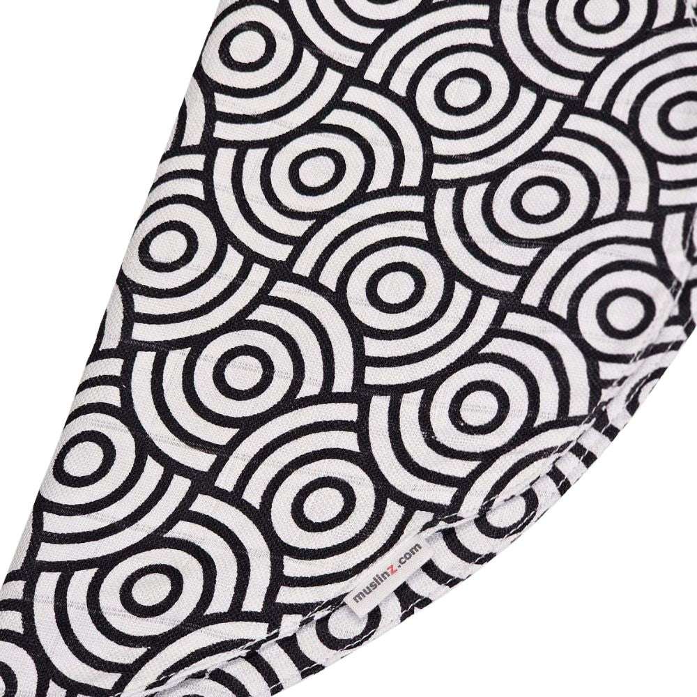 Muslinz Mini Muzi - Sensory Black and white circular patterned fabric with 'muslinz' branding.