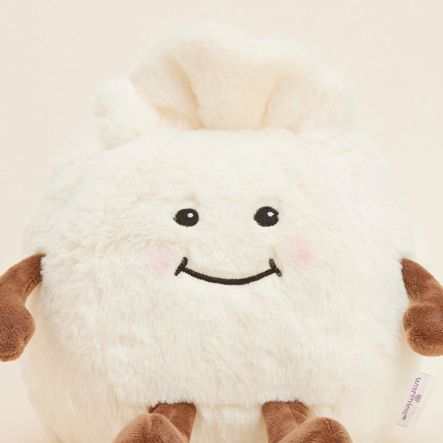 Warmies Dumpling - Plush toy with a smiling face on a beige background