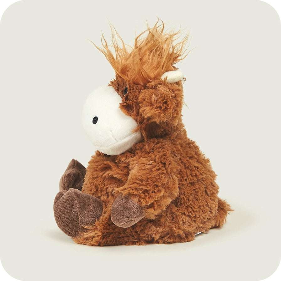 Warmies Highland Cow - Plush toy highland cow with brown fur and white face on a light gray background