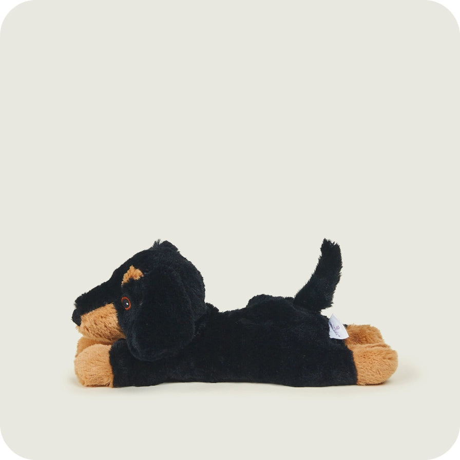 Warmies Junior Dachshund - Plush toy sausage dog with black and brown colors on a light gray background - long sideways