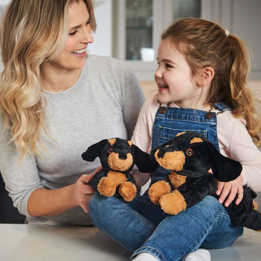 Warmies Junior Dachshund - Plush toy sausage dog with black and brown colors with a woman and child