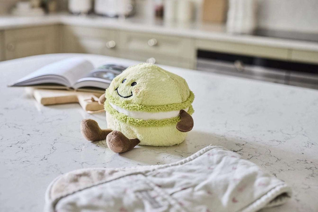 Warmies Macaroon - Plush toy macaron with a smiley face on a table