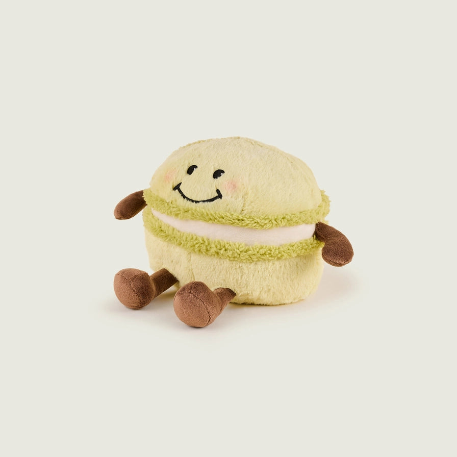 Warmies Macaroon - Plush toy macaron with a smiley face on a beige background side view