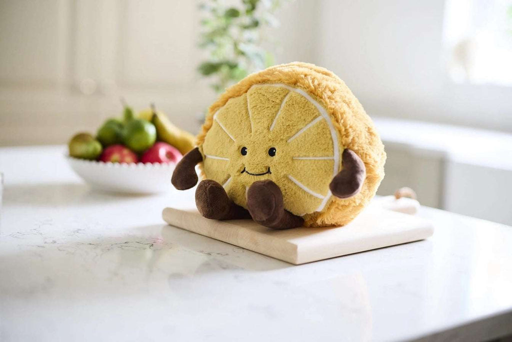 Warmies Orange Plush toy orange with a smiling face on a kitchen worktop
