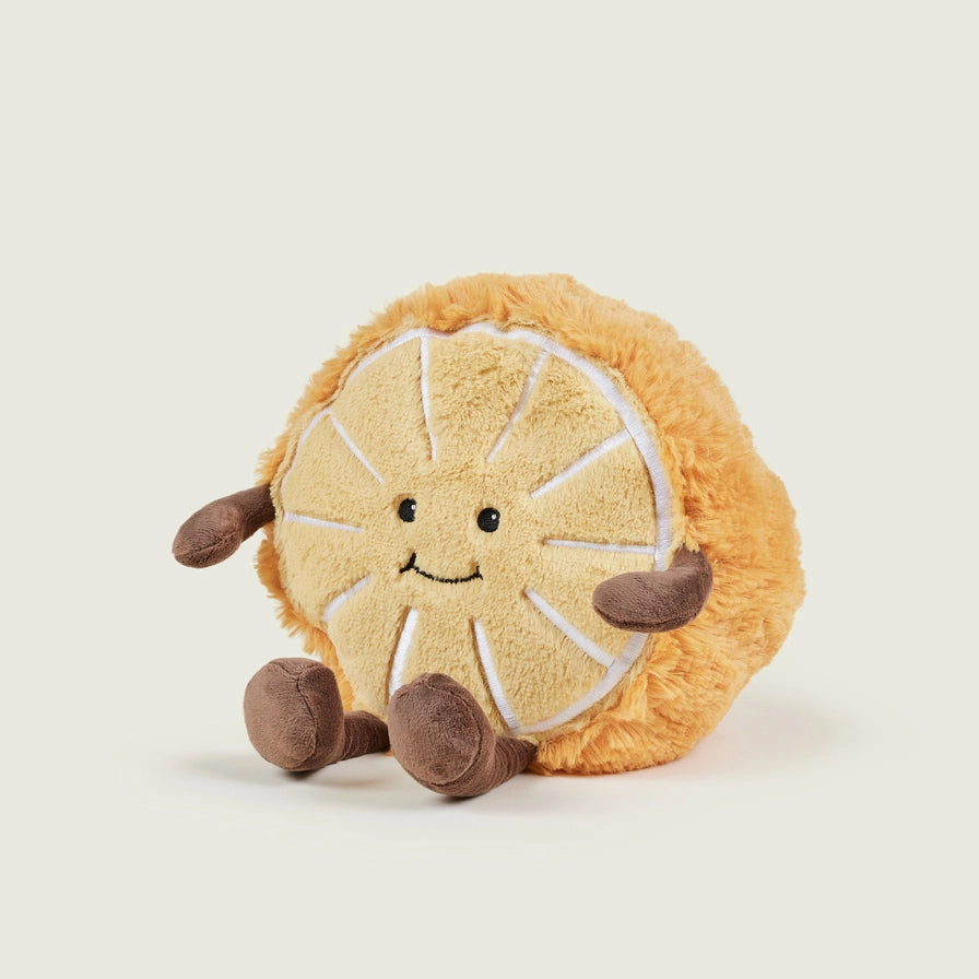 Warmies Orange Plush toy orange with a smiling face on a beige background