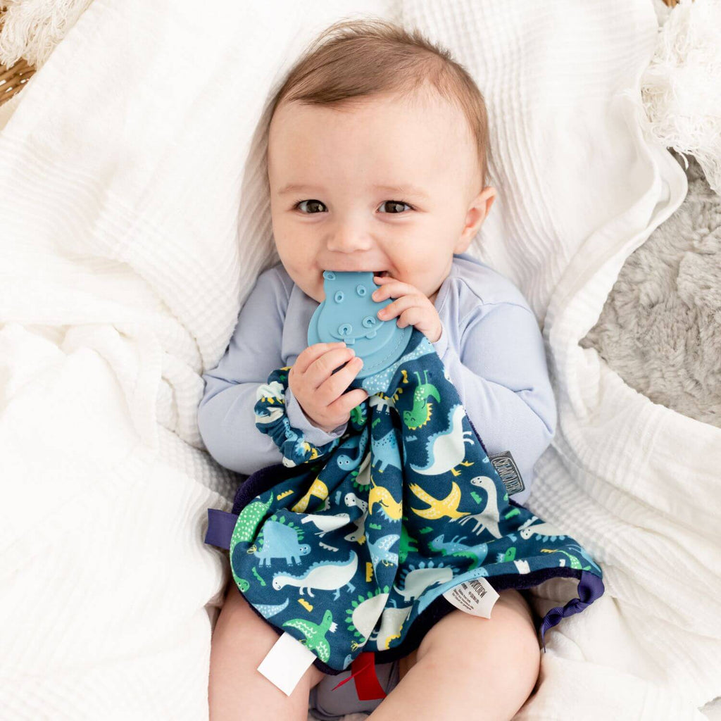 Cheeky Chompers Baby Dino Comforter & Teether. It also features a soft cuddly fleece reverse in navy, sensory ribbons for baby to play with and a teether especially designed to massage and soothe tender little gums.