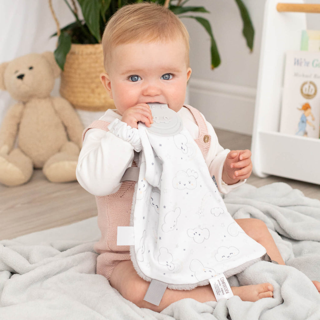 Cheeky Chompers Every Cloud Comforter & Teether. It also features a soft cuddly fleece grey reverse, sensory ribbons for baby to play with and a teether especially designed to massage and soothe tender little gums.