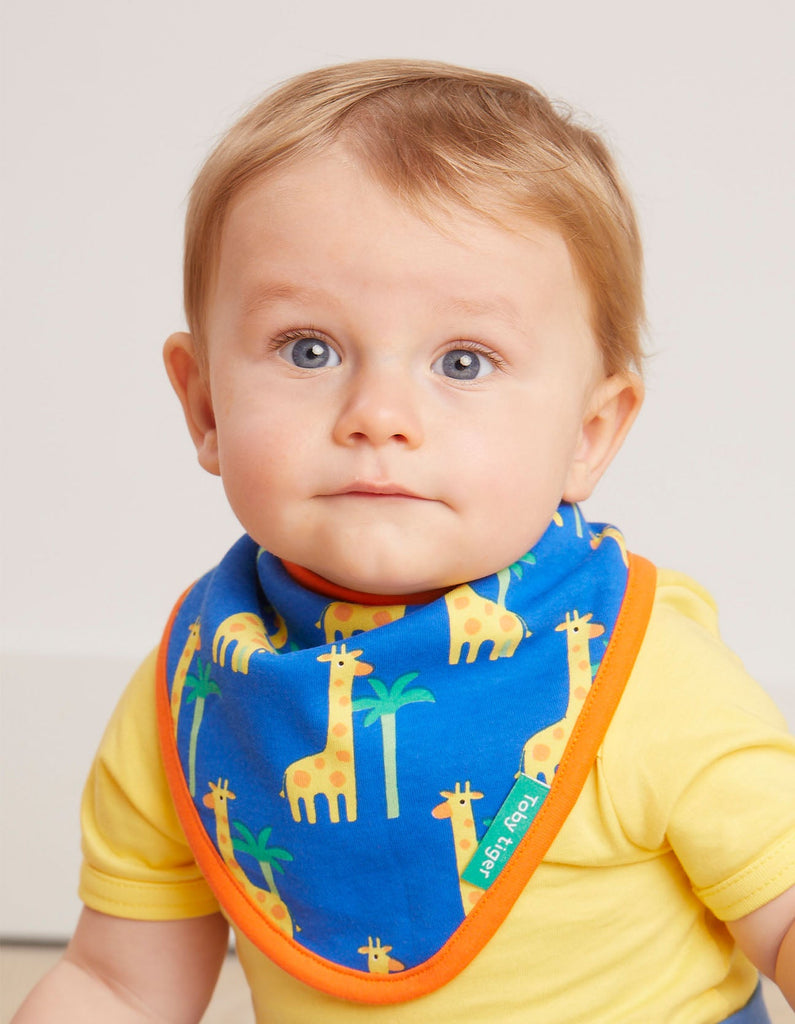 Toby Tiger Giraffe Dribble Bib - A gorgeous bib in blue featuring sweet giraffes and greenery with a bold orange trim. Organic bib. Sold by Say It Baby Gifts