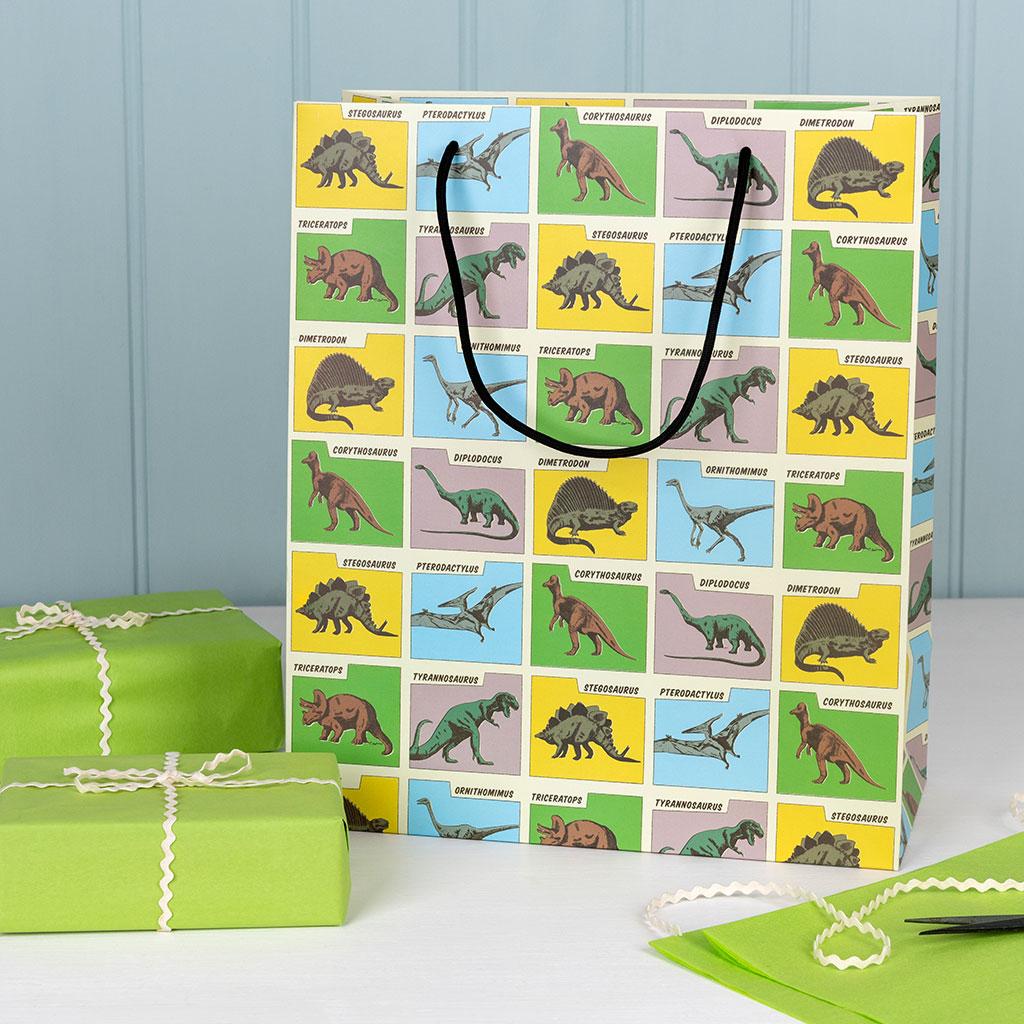 Large paper gift bag with string handles with dinosaur design.
