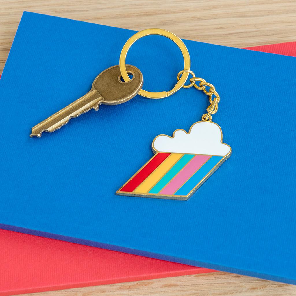 Rex London Cloud Burst Key Ring. This retro style metal keyring is in the shape of a cloud with rainbow-coloured beams - a great gift to brighten up any set of keys! Sold by Say It Baby Gifts